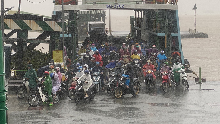 Người dân đội mưa đi làm ở bến phà Cát Lái, TP Thủ Đức- Ảnh: TỰ TRUNG