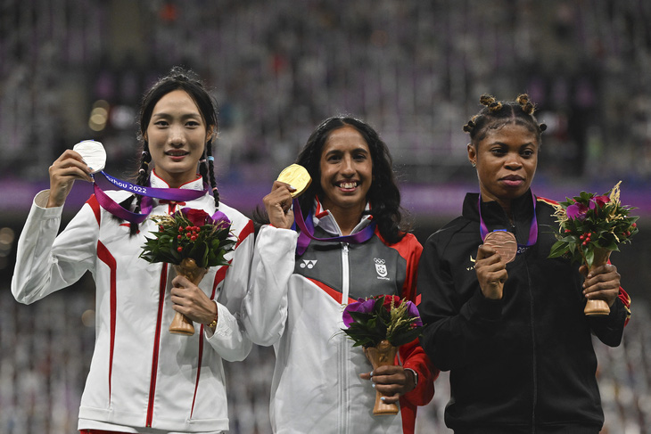 Shanti Pereira (giữa) với tấm huy chương vàng lịch sử của điền kinh Singapore - Ảnh: AFP