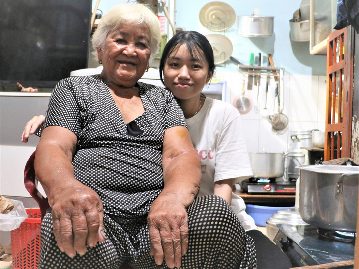 Trần Thị Hoài Trinh và bà nội bên chiếc nồi hầm đậu chuẩn bị cho mẻ xôi bán vào sáng hôm sau - Ảnh: B.MINH