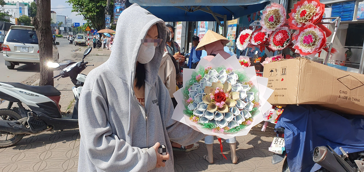 Hoa làm bằng tiền thật được bán trên đường 3 Tháng 2, quận Ninh Kiều, TP Cần Thơ - Ảnh: LÊ DÂN