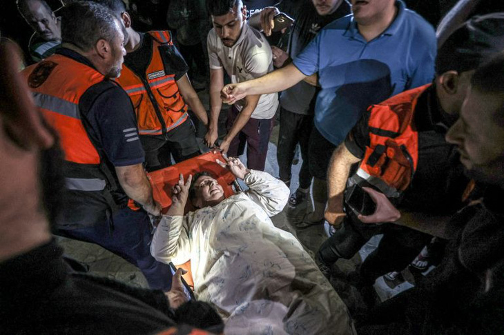 Lực lượng khẩn cấp giải cứu một phụ nữ ở nhà thờ Thánh Porphyrius, thành phố Gaza - Ảnh: ANADOLU
