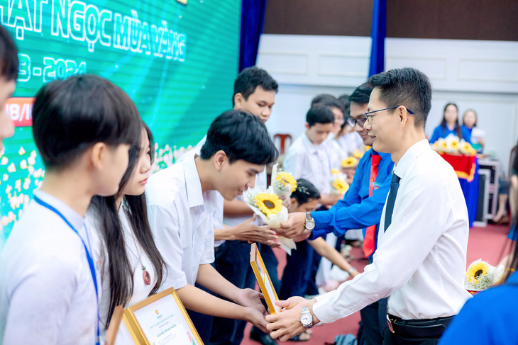 Ông Trần Chí Nguyện - phó tổng giám đốc PVCFC - trao học bổng cho các em học sinh
