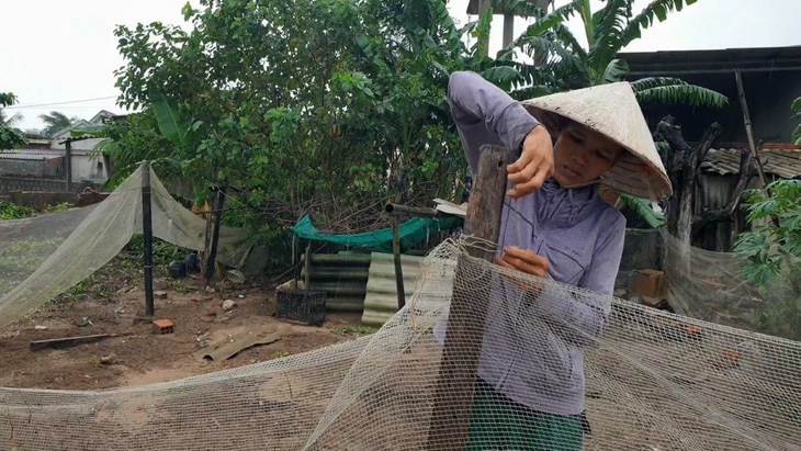 Chị Thái Thị Nhung, trú thôn Mạch Nước, xã Vĩnh Thái (Vĩnh Linh) gia cố chuồng trại để mua 200 con gà về nuôi theo chương trình Tiếp sức nhà nông - Ảnh: QUỐC NAM