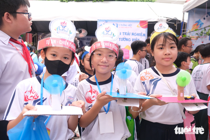 Nhóm học sinh Trường tiểu học Lê Văn Tám, quận Tân Phú thích thú khoe những chiếc quạt tự làm khi tham gia Ngày hội giáo dục STEM - Ảnh: NGỌC PHƯỢNG