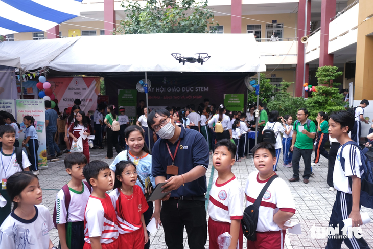 Các em học sinh trải nghiệm lái thử flycam mini tại ngày hội - Ảnh: NGỌC PHƯỢNG