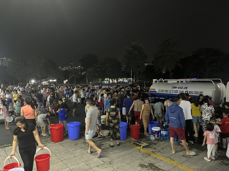 Tối 22-10, cư dân khu đô thị Thanh Hà vẫn xếp hàng để xách nước từ xe téc về nhà sử dụng - Ảnh: H.Q.