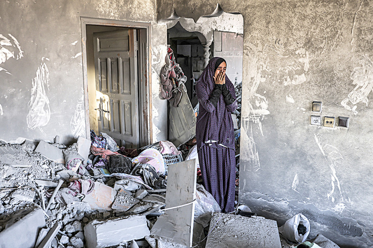 Người phụ nữ bật khóc trong ngôi nhà bị hư hại do Israel đánh bom ở Rahaf, miền nam Dải Gaza, vào ngày 19-10 - Ảnh: AFP