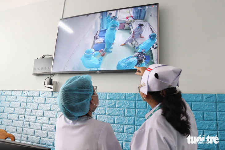 Nhân viên y tế Bệnh viện Bệnh nhiệt đới (TP.HCM) giám sát ca bệnh đậu mùa khỉ đầu tiên từng điều trị tại bệnh viện - Ảnh: XUÂN MAI