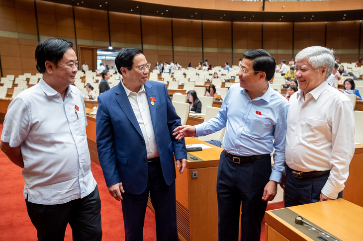 Thủ tướng Phạm Minh Chính (thứ hai từ trái sang) trao đổi cùng một số đại biểu tại kỳ họp Quốc hội - Ảnh: GIA HÂN
