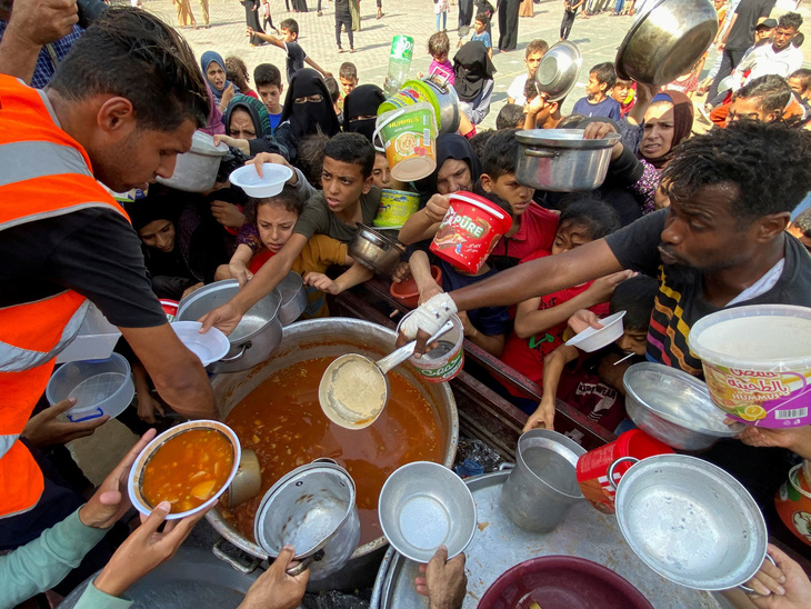 Người Palestine tụ tập để nhận phần thực phẩm từ thiện tại một điểm trú ẩn do Liên Hiệp Quốc điều hành ở Rafah, phía nam Dải Gaza, ngày 23-10 - Ảnh: REUTERS