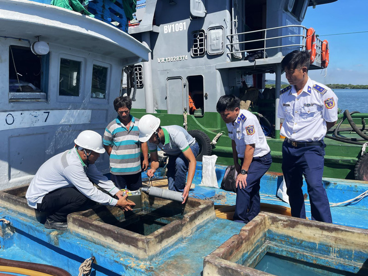 Cơ quan chức năng lấy mẫu dầu trên tàu TG 90297 TS để giám định kiểm tra chất lượng - Ảnh: Cảnh sát biển