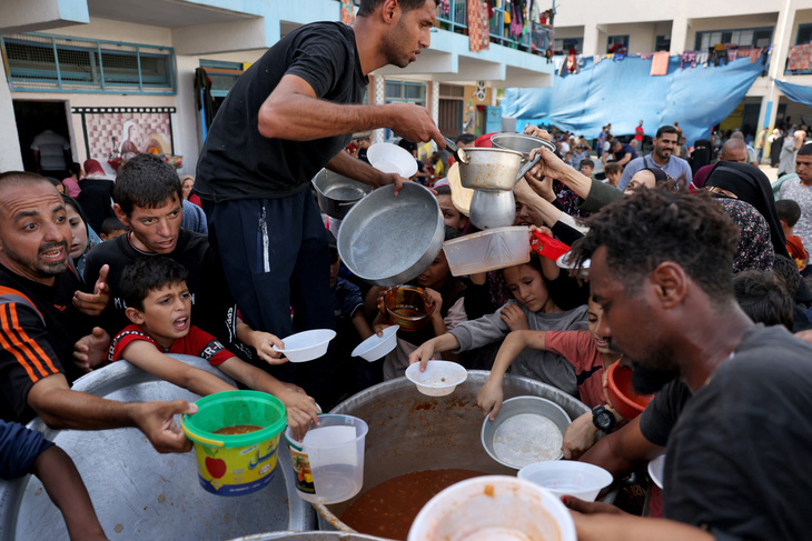 Người dân Palestine nhận thức ăn tại Rafah ở phía nam Dải Gaza ngày 23-10 - Ảnh: AFP