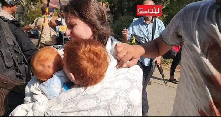 Cô Shiri ôm hai đứa con trai tóc đỏ, Ariel, 4 tuổi và bé Kfir 10 tháng tuổi bị bắt lên xe - Ảnh: DAILY MAIL