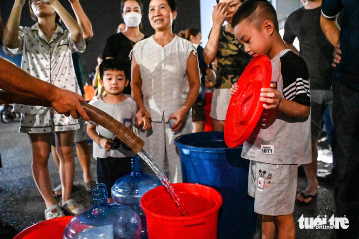 Người dân khu đô thị Thanh Hà (Thanh Oai, Hà Nội) phải hứng từng xô nước trong nhiều ngày qua để sinh hoạt - Ảnh: HỒNG QUANG