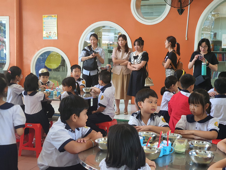 Phụ huynh quan sát bữa ăn trưa tại Trường tiểu học Nguyễn Bỉnh Khiêm - Ảnh: TRÂN TRẦN
