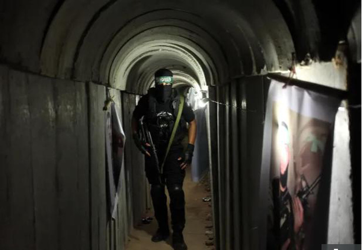 Một thành viên của Hamas đứng bên trong một trong những đường hầm nối Dải Gaza và Israel -   Ảnh: THE SUN