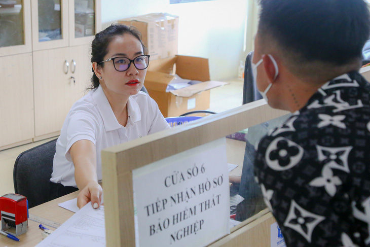 Cán bộ giải thích thủ tục bảo hiểm thất nghiệp tại Trung tâm Dịch vụ việc làm Bắc Giang - Ảnh: HÀ QUÂN