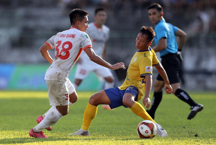 Tiền đạo Minh Quang (trái) đi bóng qua cầu thủ Đồng Tháp - Ảnh: THẮNG LÊ