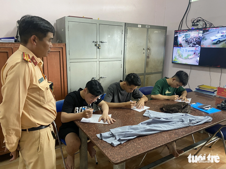 Cảnh sát giao thông mời Hào, Huy và Tân lên làm việc - Ảnh: HOÀI THƯƠNG