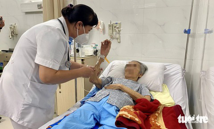 Bác sĩ CKII Trần Thị Vân Anh - trưởng khoa nội nhiễm Bệnh viện Thống Nhất - thăm khám bệnh nhân 80 tuổi bị viêm não do vi rút Herpes - Ảnh: XUÂN MAI