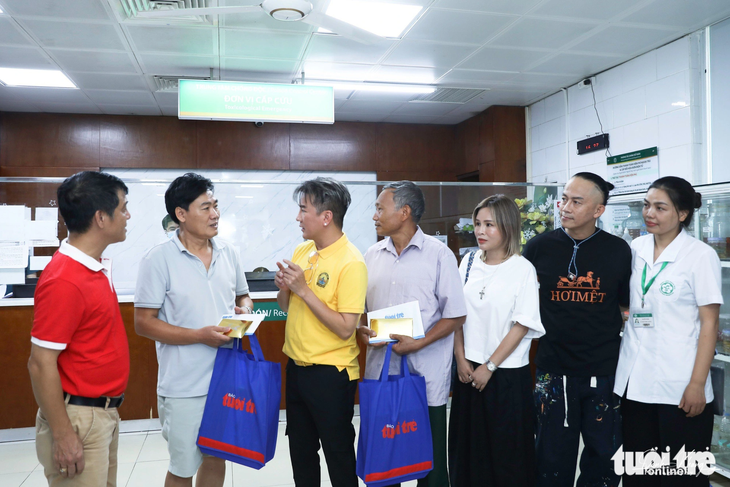 Ca sĩ Đàm Vĩnh Hưng, đại diện báo Tuổi Trẻ, các nhà hảo tâm thăm hỏi động viên bệnh nhân đang điều trị tại Bệnh viện Bạch Mai - Ảnh: DANH KHANG