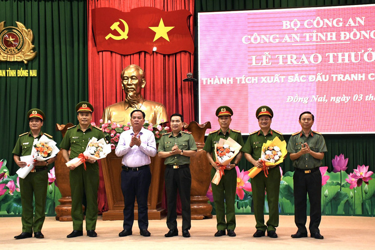 Quyền Chủ tịch UBND tỉnh Võ Tấn Đức và Thiếu tướng Nguyễn Sỹ Quang - giám đốc Công an tỉnh - trao thưởng cho các đơn vị - Ảnh: H.M.