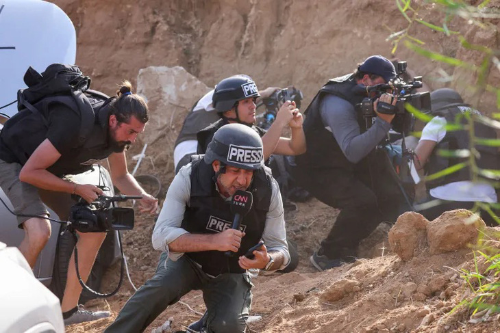 Các phóng viên ẩn nấp tại thành phố Sderot của Israel khi nghe thấy còi báo động không kích từ Dải Gaza, ảnh chụp ngày 23-10 - Ảnh: AFP