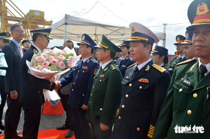 Thiếu tướng Trần Văn Thơ - tư lệnh Vùng cảnh sát biển 1 - tặng hoa chúc mừng ông Kim Young Chul (trái) và đoàn công tác Lực lượng bảo vệ bờ biển Hàn Quốc - Ảnh: MẠNH THƯỜNG