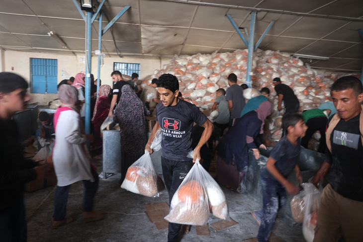 Người Palestine ở Dải Gaza xông vào kho viện trợ của Liên Hiệp Quốc để tự ý lấy thực phẩm ở thành phố Deir al-Balah. Số thực phẩm này dùng để phân phối cho người dân di dời về phía Nam theo lời kêu gọi của Israel, ngày 28-10 - Ảnh: AFP