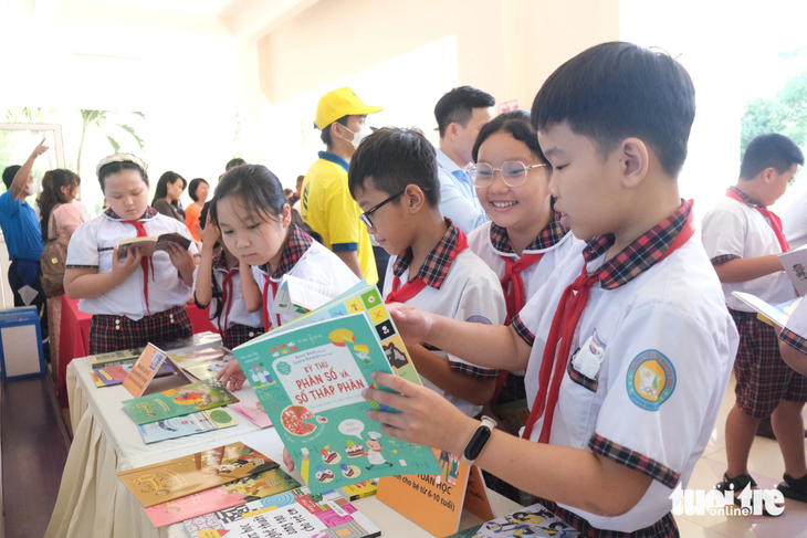 Học sinh Trường tiểu học Nguyễn Bình (huyện Nhà Bè, TP.HCM) thích thú đọc sách tại lễ bàn giao sách diễn ra trong sáng 31-10 - Ảnh: NGỌC PHƯỢNG