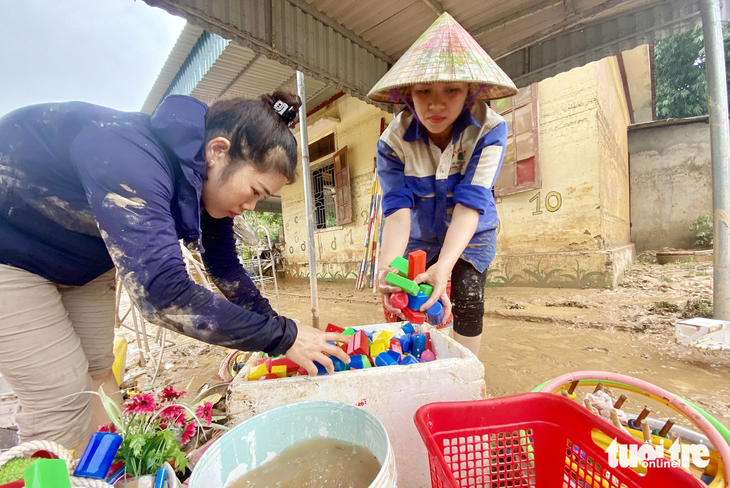 Các cô giáo Trường mầm non Châu Hạnh, huyện Quỳ Châu, Nghệ An rửa lại đồ chơi của học trò sau mưa lũ - Ảnh: DOÃN HÒA