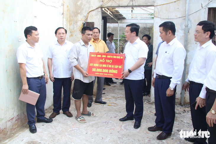 Ông Nguyễn Đức Trung - phó bí thư Tỉnh ủy, chủ tịch UBND tỉnh Nghệ An - trao tiền hỗ trợ cho người dân Quỳ Châu xây dựng lại nhà ở sau mưa lũ - Ảnh: DOÃN HÒA