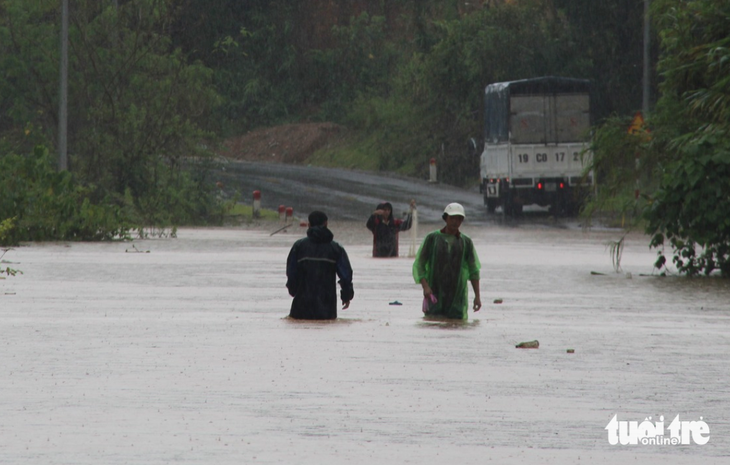 Người dân Quỳ Châu, Nghệ An lội nước qua đoạn đường ngập do mưa lũ ngày 27-9 - Ảnh: KẾ KIÊN