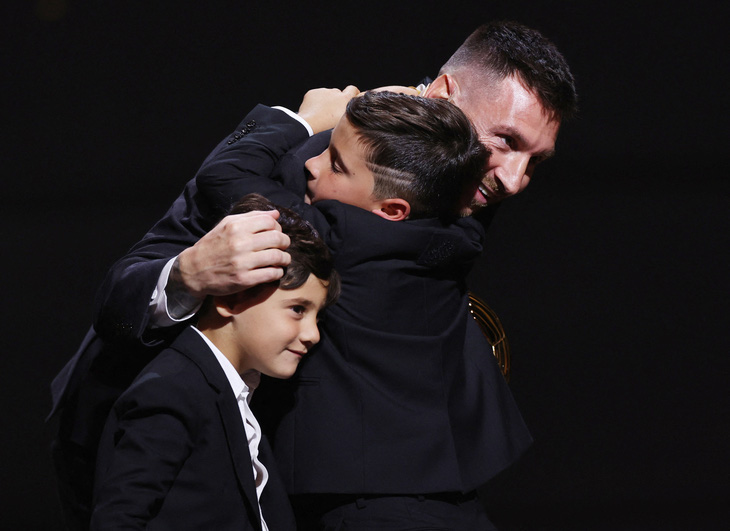 Messi ôm các con trai khi lên nhận giải &quot;Quả bóng vàng&quot; thứ 8 trong sự nghiệp - Ảnh: REUTERS