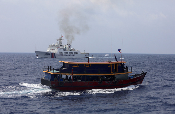 Tàu tiếp tế treo cờ Philippines và phía xa là tàu hải cảnh Trung Quốc ở Biển Đông, ngày 4-10 - Ảnh: REUTERS
