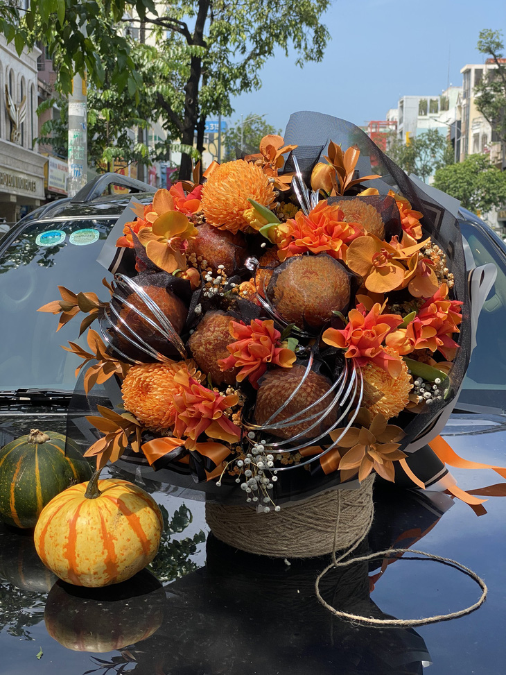 Một mẫu hoa được thiết kế riêng cho mùa Halloween. Để tạo điểm nhấn &quot;ma mị&quot;, hoa được sơn thêm sắc cam và phủ một lớp voan đen kỳ bí, giá bó hoa đang được niêm yết 1,7 triệu đồng/bó - Ảnh: Dalat Hasfarm