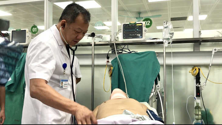 Ông Dương Đức Hùng - giám đốc bệnh viện Việt Đức - kiểm tra tình trạng nạn nhân vụ tai nạn - Ảnh: D.LIỄU