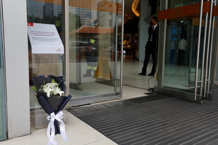 Bó hoa và bảng tưởng niệm được đặt trước cửa trung tâm thương mại Siam Paragon để tưởng niệm các nạn nhân vụ xả súng chiều 3-10 - Ảnh: REUTERS