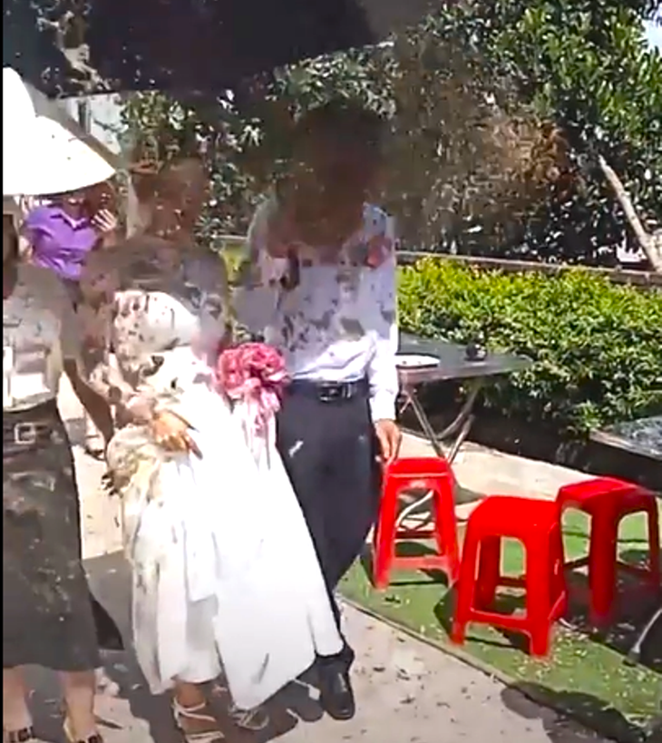 Khoảnh khắc cô dâu chú rể bị hắt chất bẩn vào người  - Ảnh: Cắt từ clip