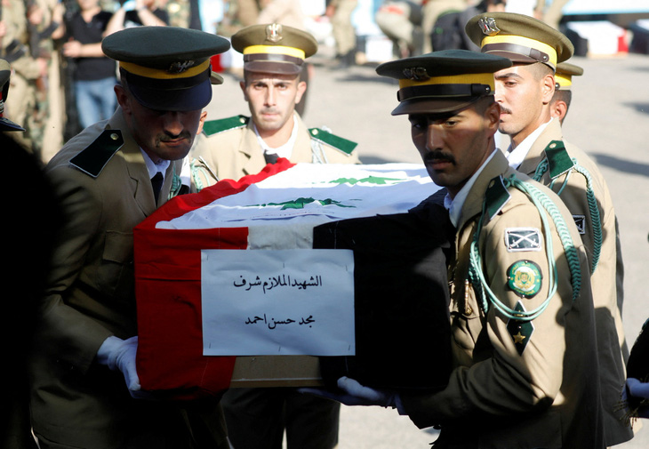 Các thành viên đội danh dự khiêng quan tài của một trong những nạn nhân thiệt mạng trong vụ tấn công vào học viện quân sự ở Homs, Syria ngày 6-10 - Ảnh: REUTERS