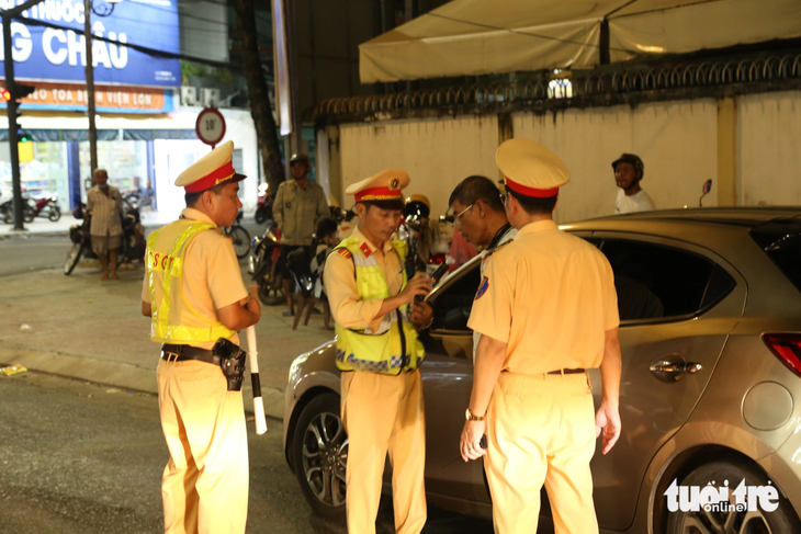 Cảnh sát kiểm tra nồng độ cồn với các tài xế lái ô tô - Ảnh: HOÀI THƯƠNG