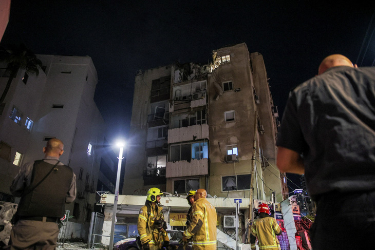Hiện trường tại một tòa nhà trúng rocket ở thành phố Tel Aviv, Israel hôm 7-10 - Ảnh: REUTERS