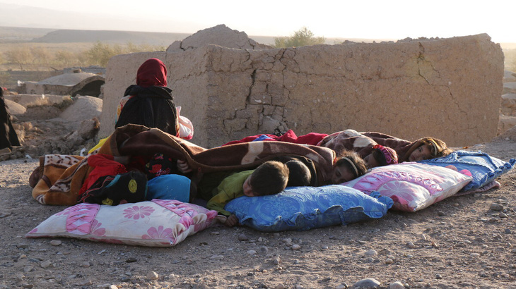Trẻ em Afghanistan ngủ ngoài trời bên cạnh nhà cửa đã bị phá hủy do động đất - Ảnh: AFP