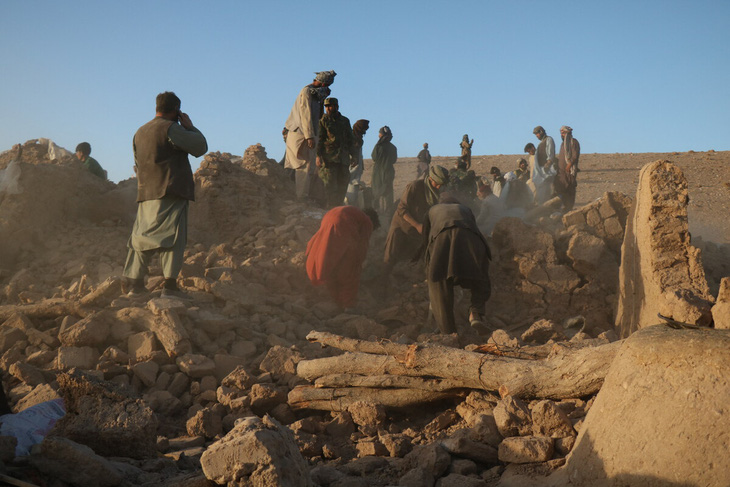 Người dân dọn dẹp đống đổ nát sau động đất tại làng Sarbuland, Afghanistan ngày 7-10 - Ảnh: AFP