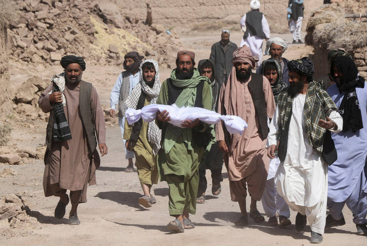 Một người cha Afghanistan bế con đã qua đời trên tay - Ảnh: REUTERS