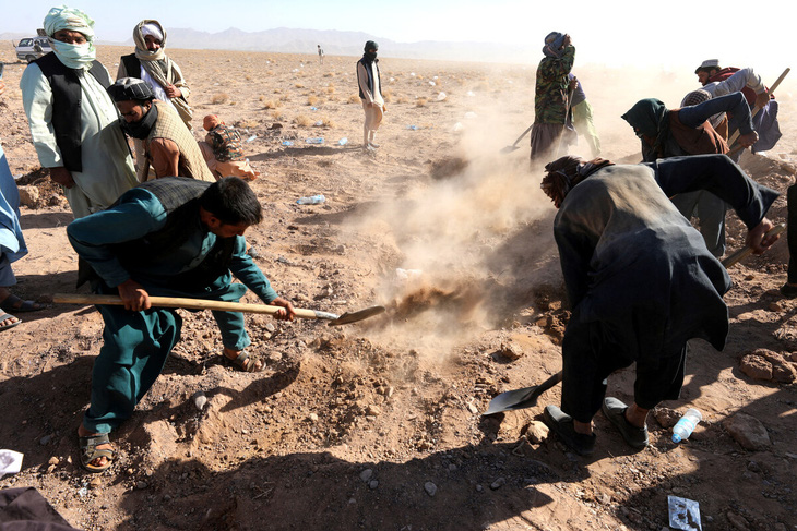 Người dân chôn thi thể nạn nhân của trận động đất - Ảnh: AFP