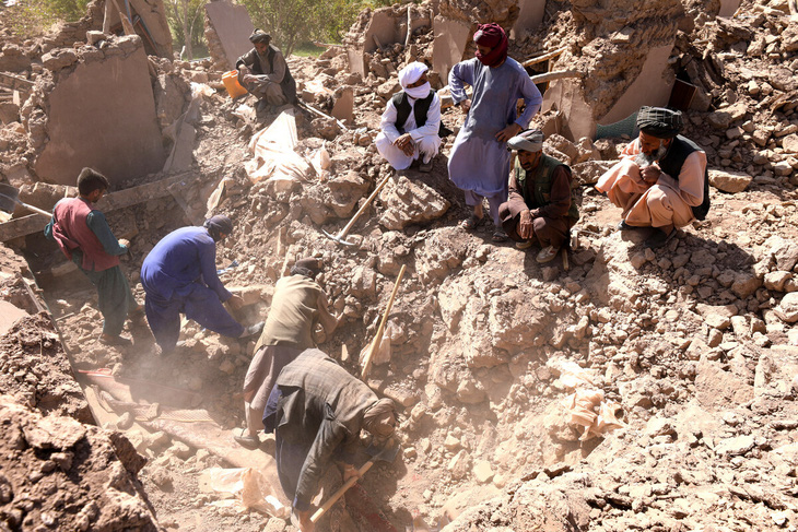 Người dân dùng dụng cụ thô sơ để tìm kiếm các nạn nhân - Ảnh: AFP