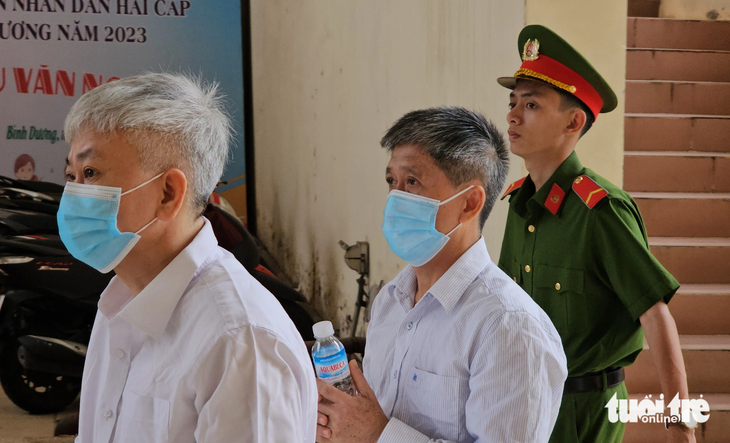 Ông Lê Minh Quốc Cường (giữa) - cựu giám đốc Sở Lao động - Thương binh và Xã hội tỉnh Bình Dương - được dẫn giải tới tòa sáng 9-10 - Ảnh: BÁ SƠN