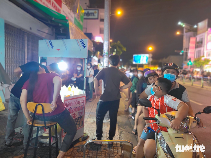 Khách xếp hàng tràn xuống lề đường trước một tiệm bánh đồng xu nằm trên đường Phan Văn Trị (quận Gò Vấp) lúc 20h30 tối cuối tuần - Ảnh: NHẬT XUÂN