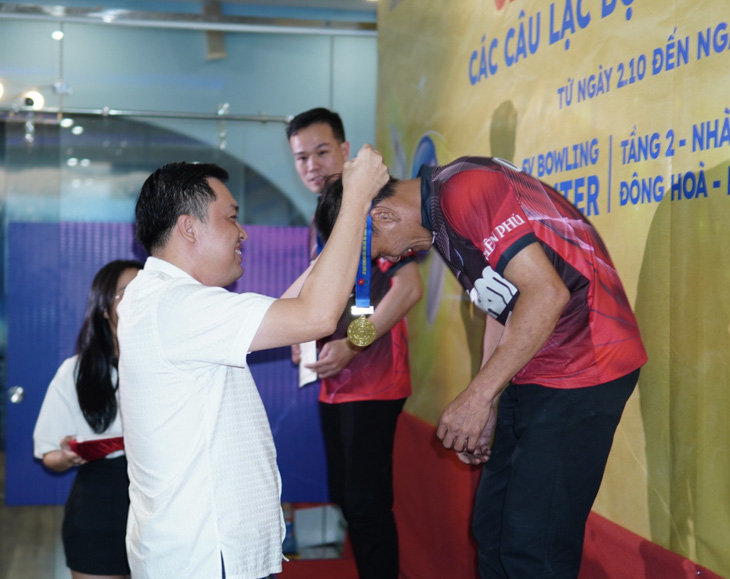 Phó giám đốc Sở Văn hóa, Thể thao và Du lịch tỉnh Bình Dương Cao Văn Chóng (trái) trao huy chương cho VĐV - Ảnh: NHẬT NAM